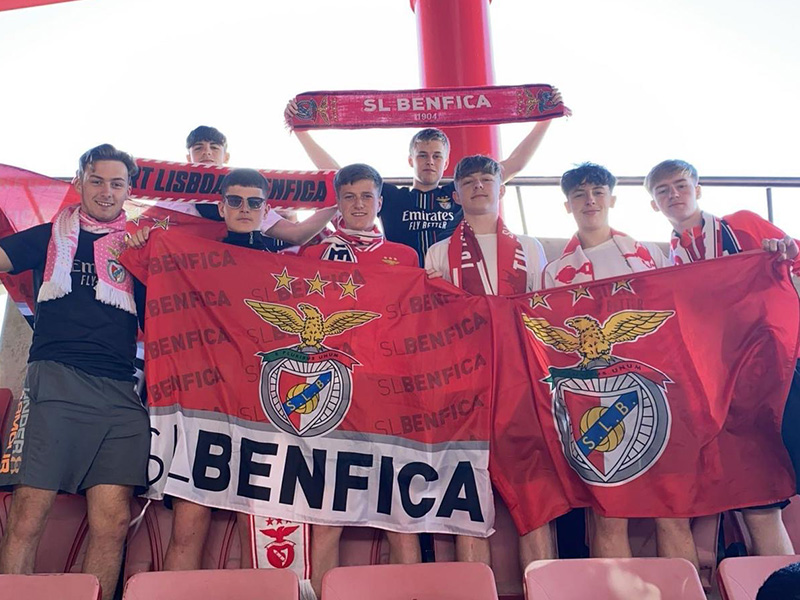 Myfyrwyr hapus ym Mhortiwgal yn dal baner SL Benfica