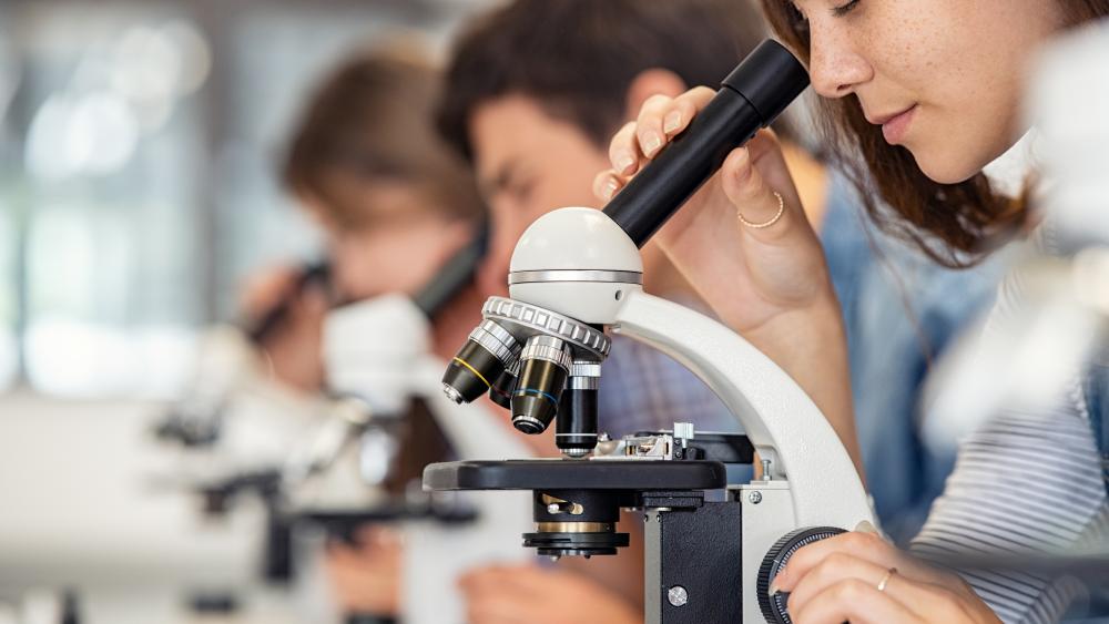two students in lab coats in a laboratory